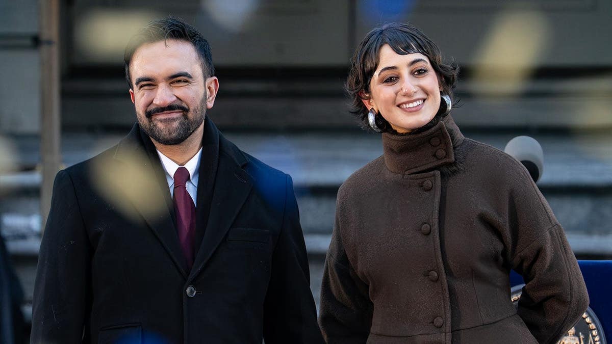 Zohran Mamdani and Rama Duwaji smile as confetti falls at City Hall during inauguration.