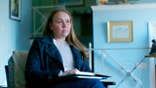 Kara Robinson Chamberlain looking up while holding cold case files.