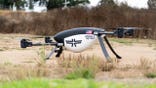 A firefighting drone sits in a field.