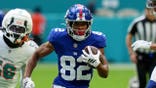 Calvin Austin III runs with the ball during a preseason NFL game between the Giants and Dolphins.