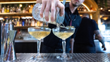 A bartender pours cocktails.