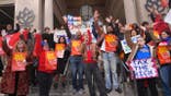 NYC-DSA members hold signs during a rally in Union Square.