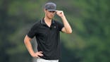Garrett Clark adjusts his hat on the 15th green at East Lake Golf Club.