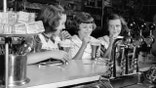Three girls drink ice cream floats from a counter in 1952.