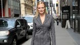 Heather Graham in pin stripe suit walking