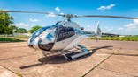Helicopter sits ready for departure at a heliport.