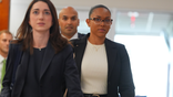 McKenna West walks through a Dallas courthouse with her legal team