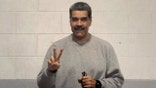 nicolas maduro in gray sweatsuit holding a peace sign and smiling