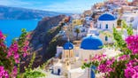 White houses and blue-domed churches overlook the caldera in Oia, Santorini, Greece.