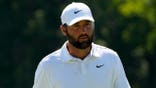 Scottie Scheffler walks off the 18th green during a golf tournament.