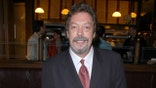 Tim Curry smiles for the camera at a restaurant in NYC.