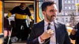 Zohran Mamdani greets bus driver during New York City campaign event.