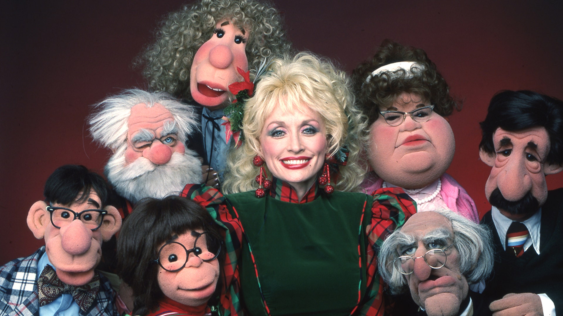 Dolly Parton posing with puppets on her show in 1987.