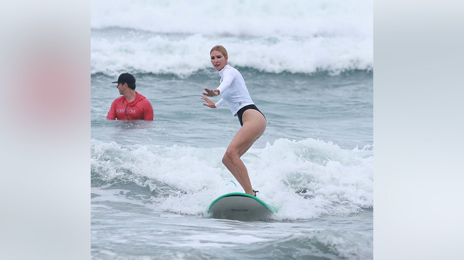 Ivanak Trump standing on a surfboard.