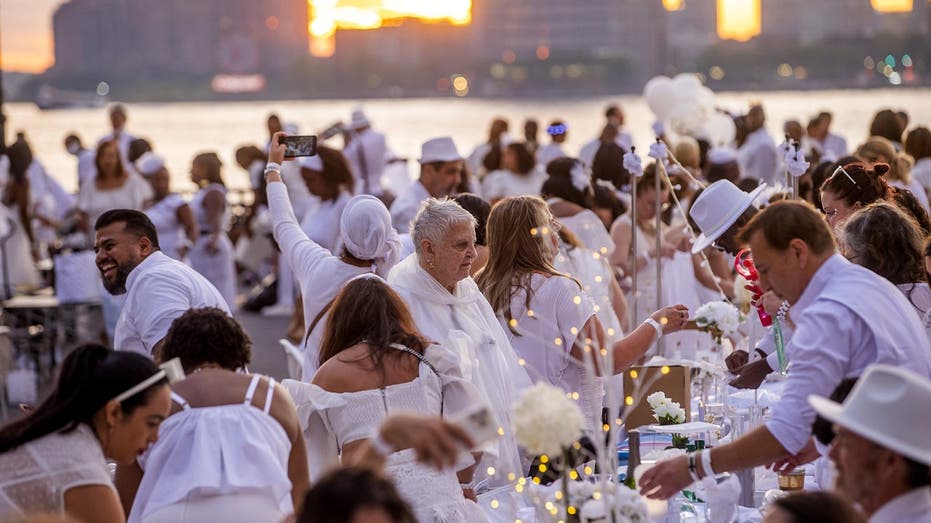 Dinner party has guests bringing tables, dressing in white and learning location last-minute