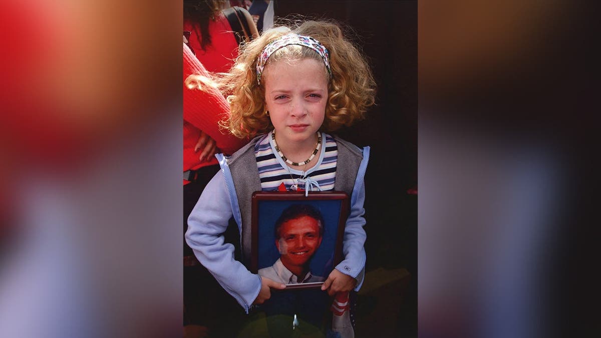 image shows girl holding photo of victim