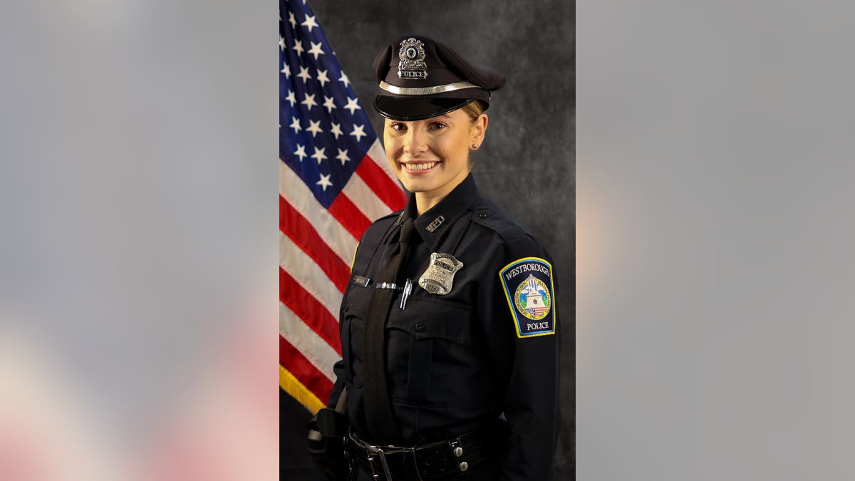 Ashlyn Mercier in a police uniform in front of the American flag.