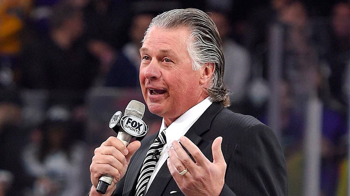 Barry Melrose speaks to fans at an NHL game