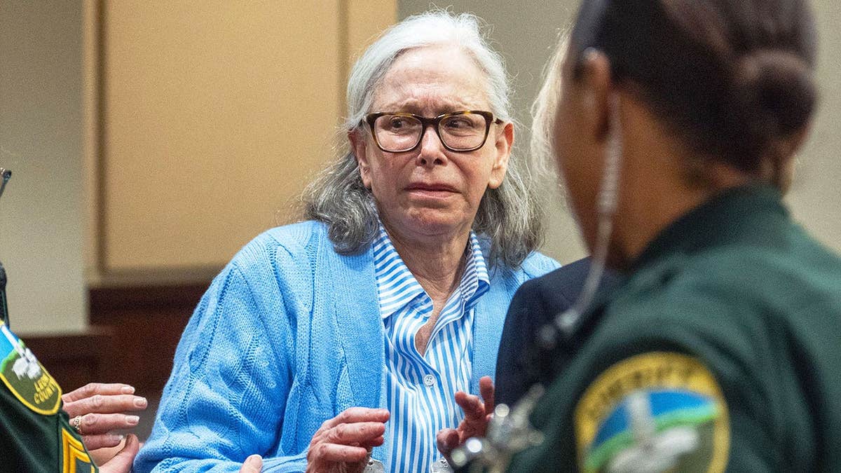 Donna Adelson crying while being escorted by police after being found guilty of murder.