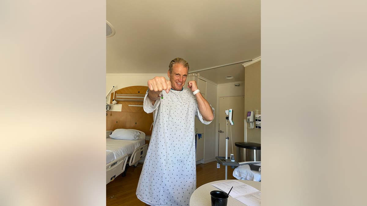 Dolph Lundgren throwing a punch wearing a hospital gown.