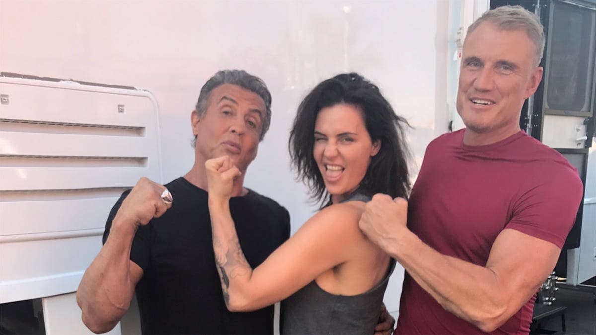 Dolph Lundgren is on set with Sylvester Stallone throwing a punch.