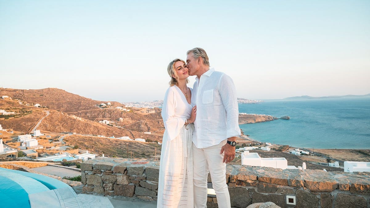 Dolph Lundgren and his wife in Greece wearing matching white ensembles.