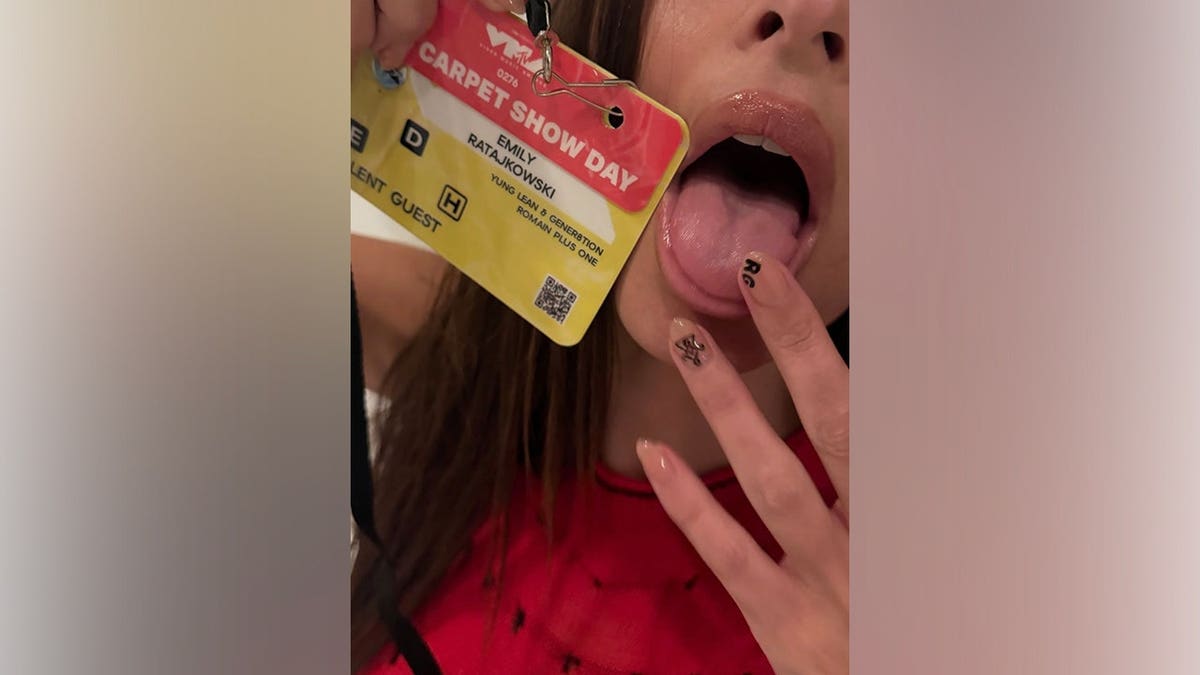 Emily Ratajkowski shows her manicure and VMAs guest pass in a close-up selfie.