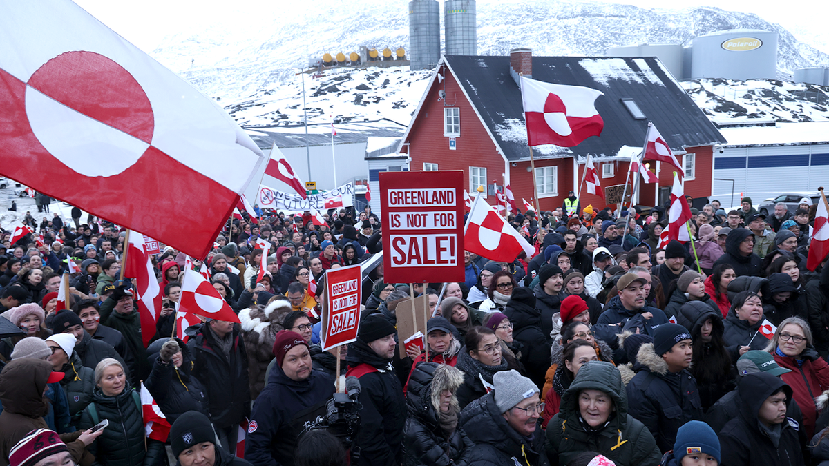 Protesters hold Greenlandic flags during demonstration outside U.S. Consulate.
