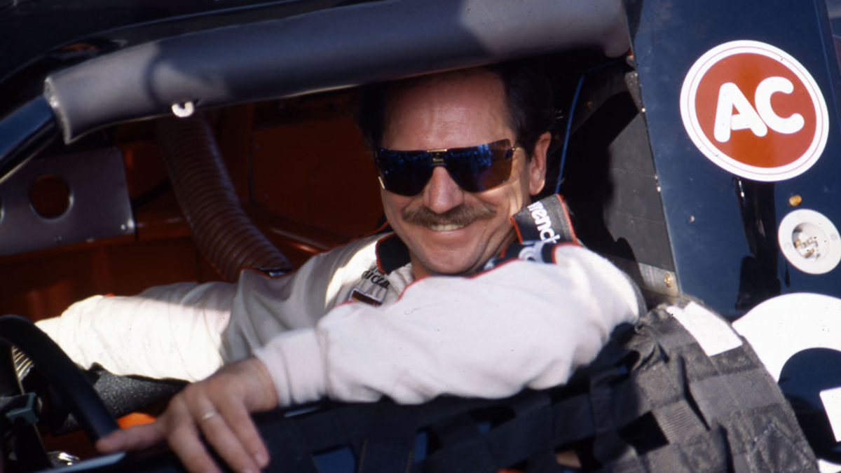Dale Earnhardt smiles from the drivers seat of his race car