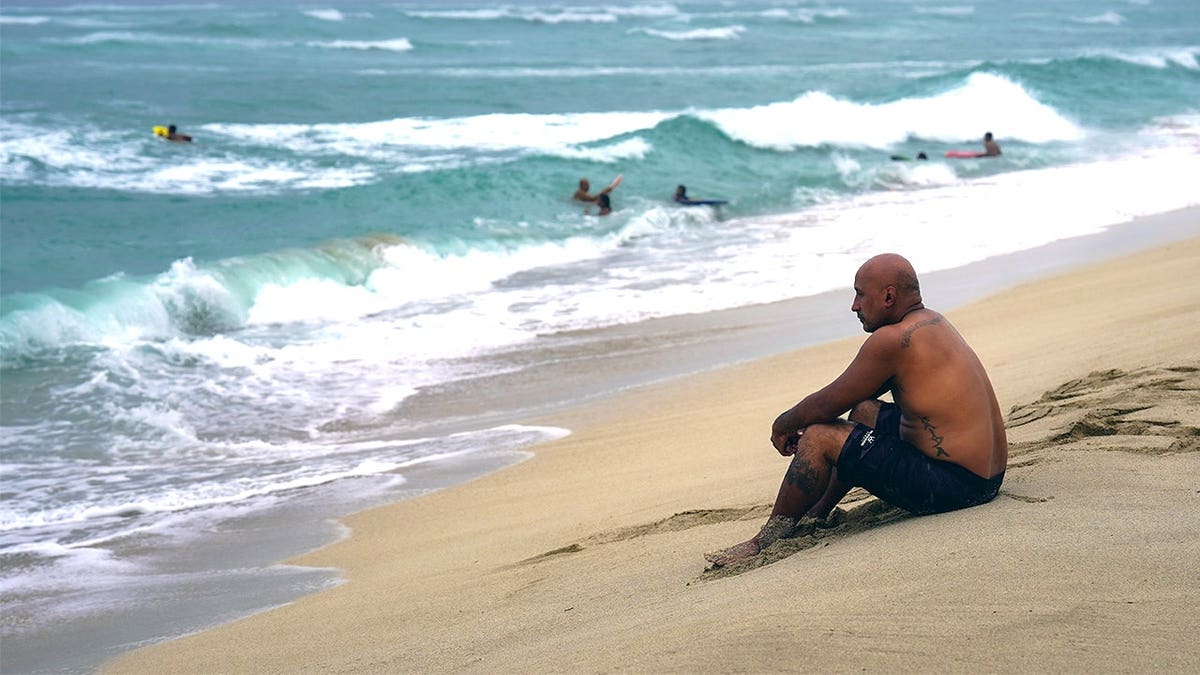 Man sitting on beach in Kauai