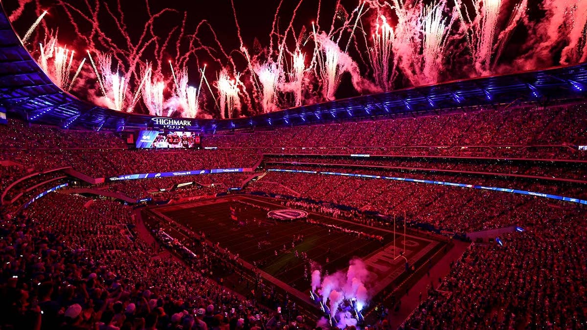 Buffalo Bills players running onto the field at Highmark Stadium amid fireworks