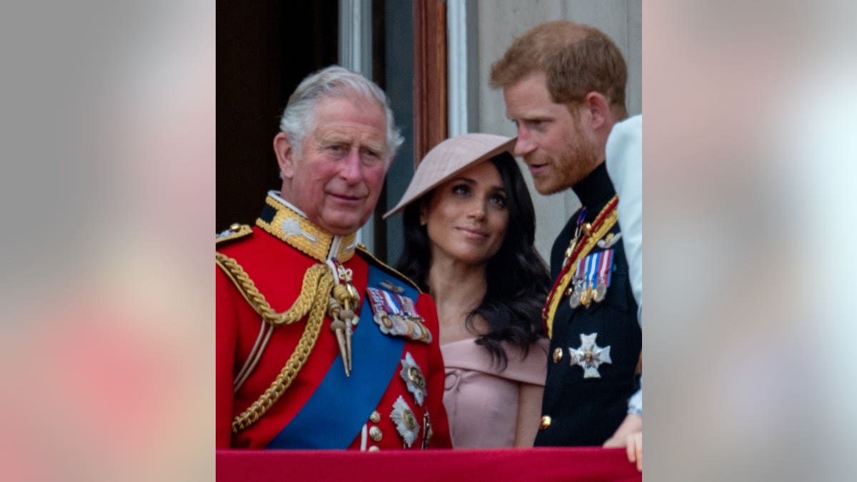 Prince Charles, Prince of Wales stands with Prince Harry, Duke of Sussex and Meghan, Duchess of Sussex.