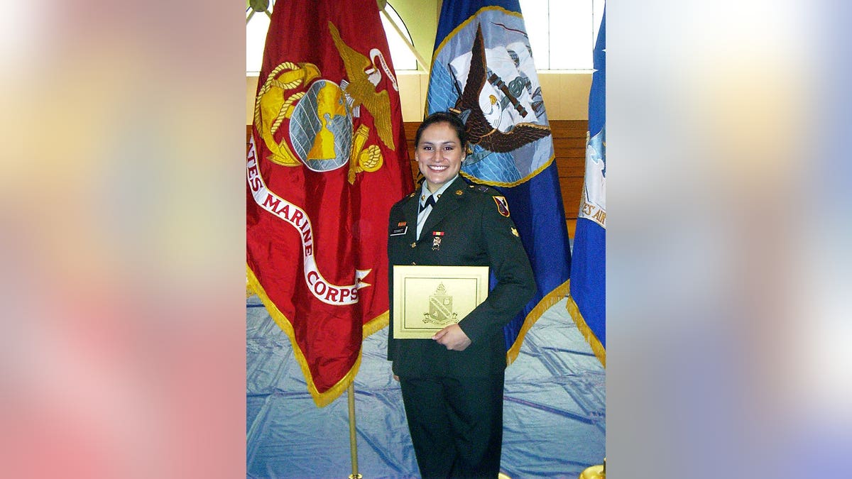 Lindsey Schmidt in uniform during her graduation near several flags.