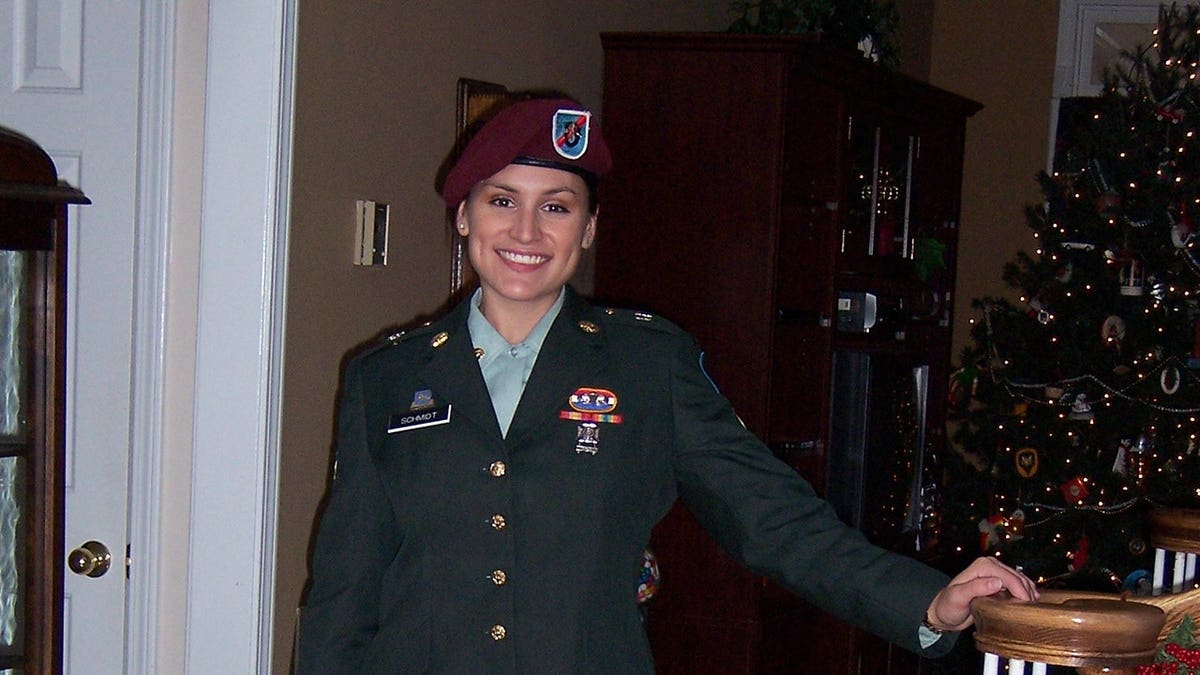 Lindsey Schmidt in military uniform near a Christmas tree.