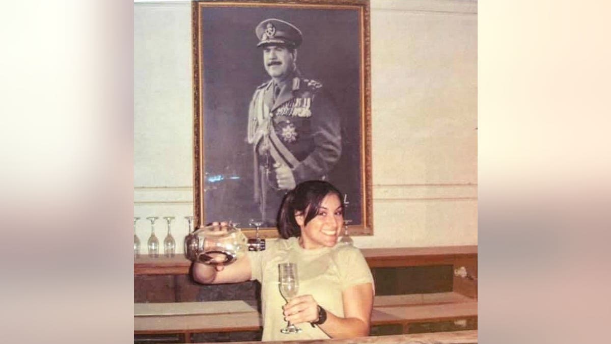 Lindsey Schmidt serving herself a glass of wine inside Saddam Hussein's palace.