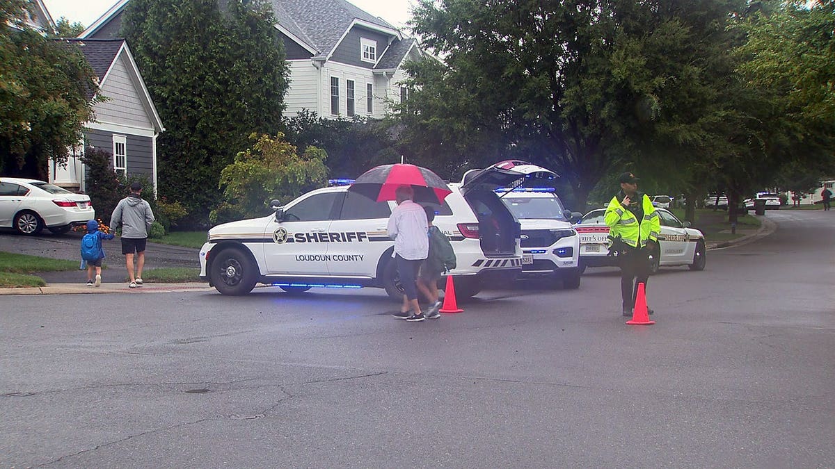 Loudoun County Sheriff's Office vehicles and deputies at the scene of a fatal shooting in Aldie, Virginia.