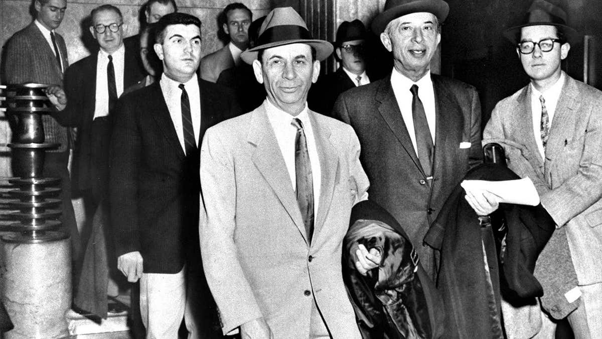 Meyer Lansky está sentado junto a su abogado, Morris Polankoff.