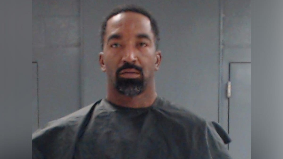 JR Smith stares ahead while wearing prison smocks during mugshot in Texas.