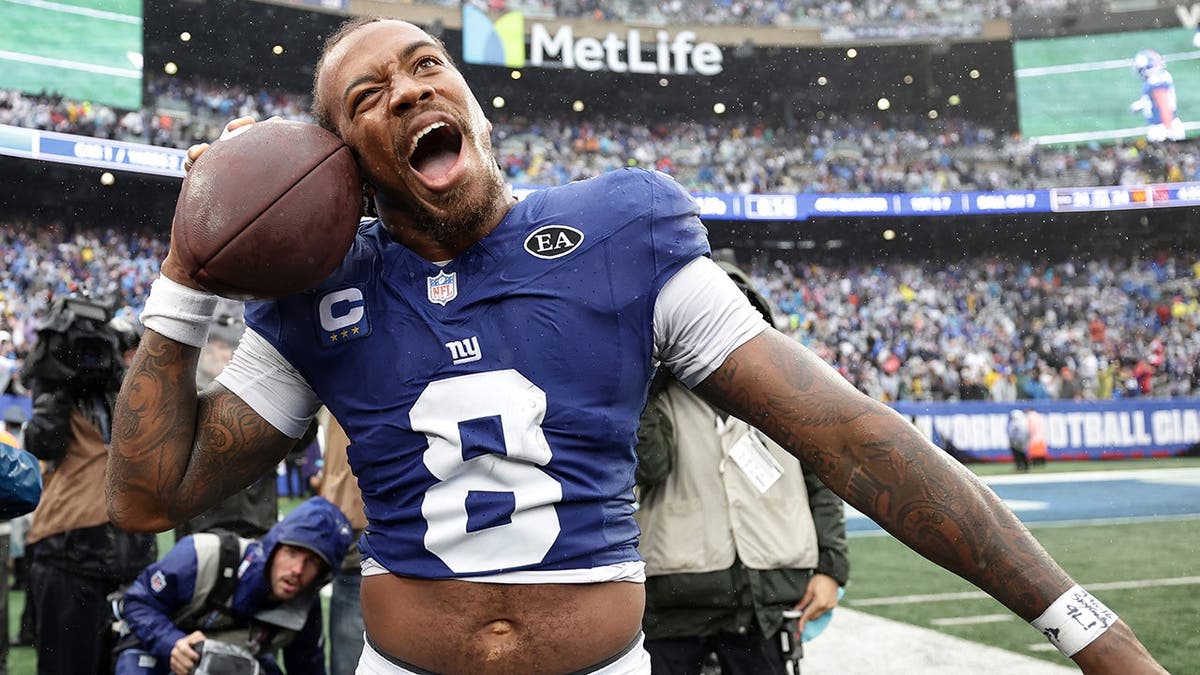Jevon Holland celebrates on the sideline after an interception.