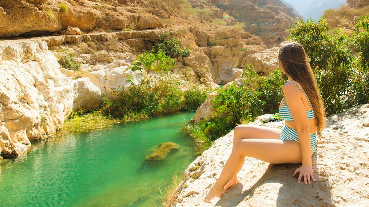 Woman bathing in water in Oman