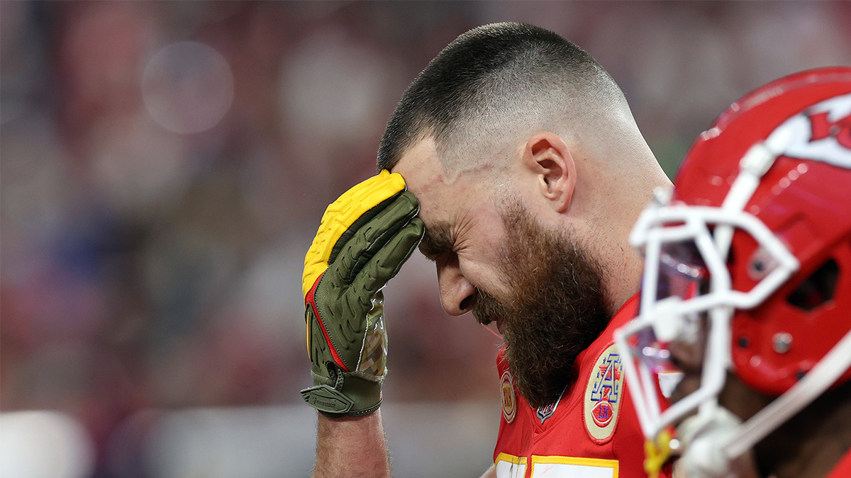 Travis Kelce with his face in his hands