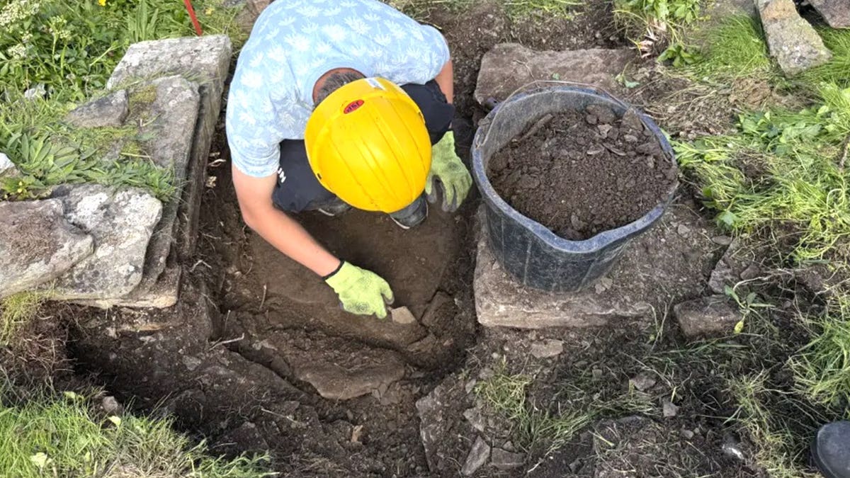 View of student digging near altar