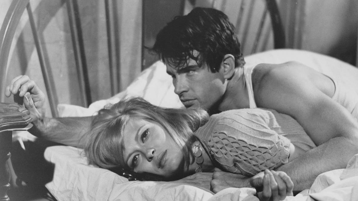 Faye Dunaway and Warren Beatty lie in bed as Bonnie Parker and Clyde Barrow.