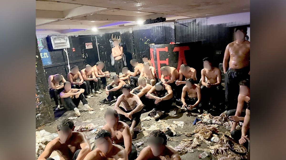 Partially clothed young men sit and stand inside the basement of an Alpha Epsilon Pi fraternity house in Madison, Wisconsin.