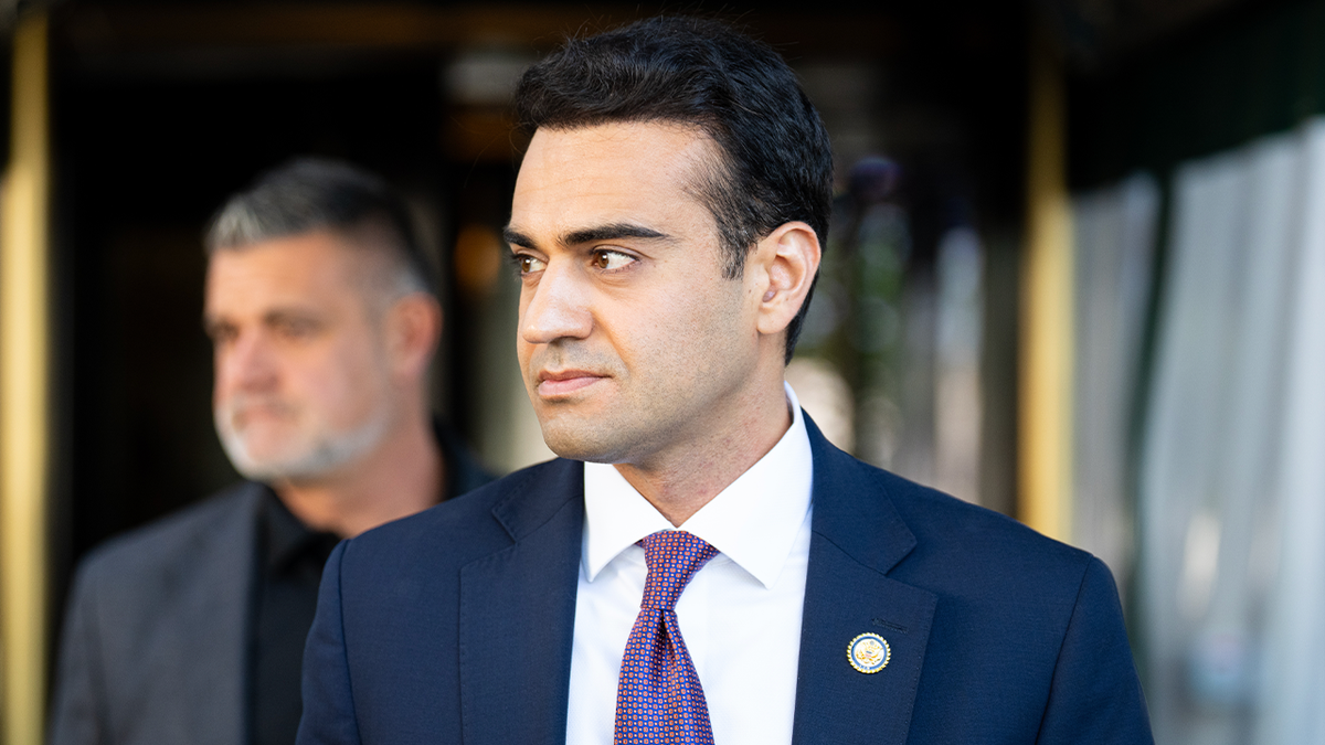 Arizona Rep. Abe Hamadeh stands outside wearing a suit and congressional pin.