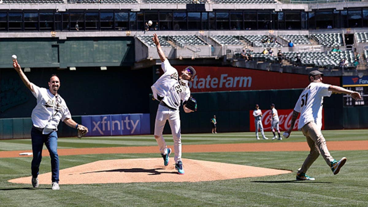 Adam Rosales, Eric Byrnes and Dallas Braden throw out the opening pitch at the Oakland Coliseum.
