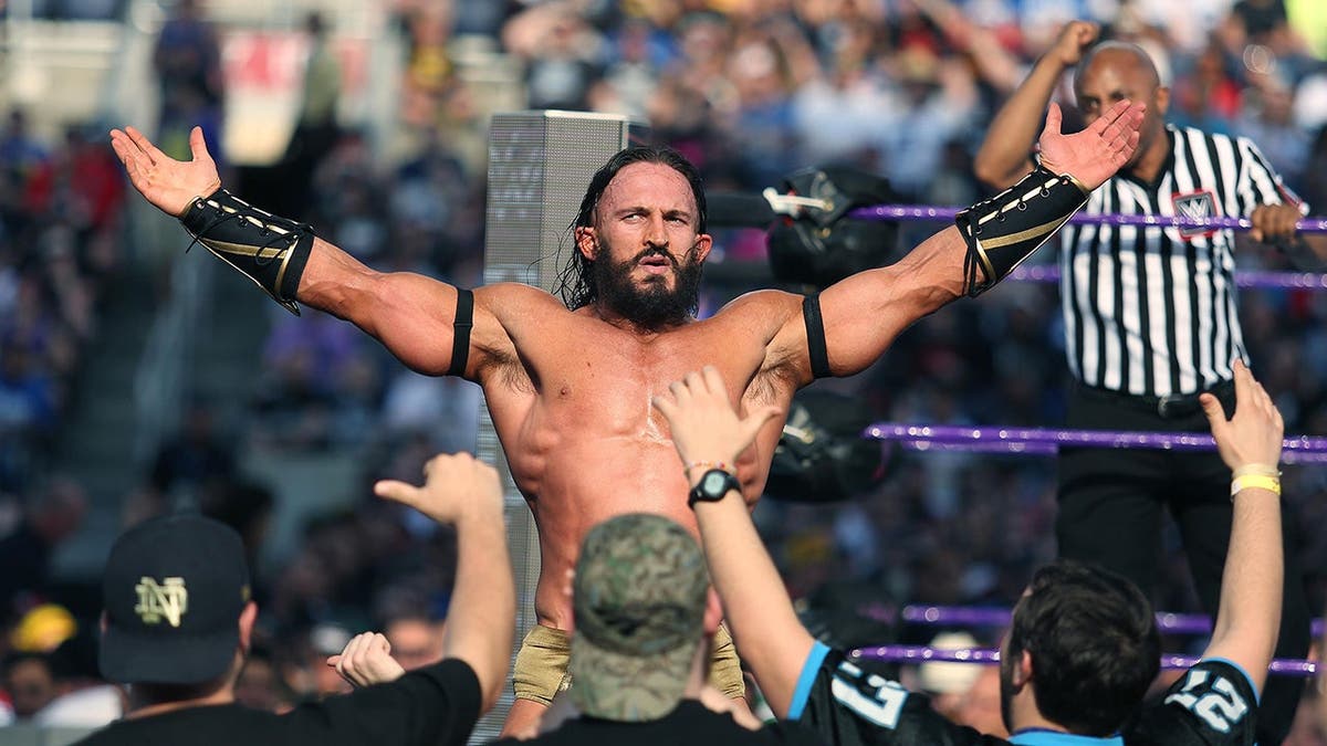 Adrian Neville celebrates with fans at Camping World Stadium.