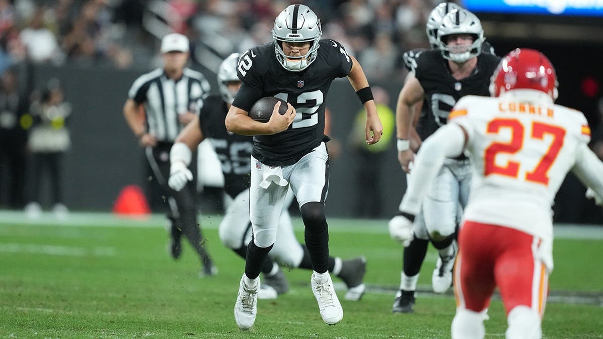 Aidan O'Connell carries the ball against Kansas City Chiefs at Allegiant Stadium.