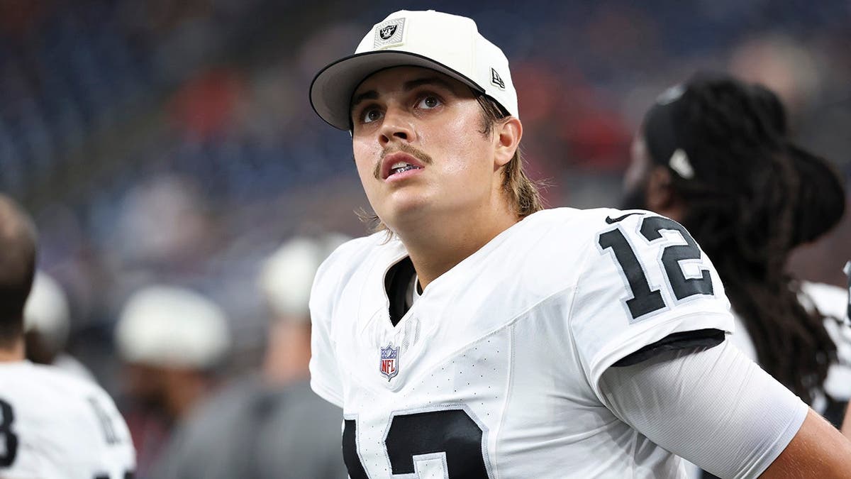 Aidan O'Connell stands on the sideline wearing a Raiders uniform during a game.