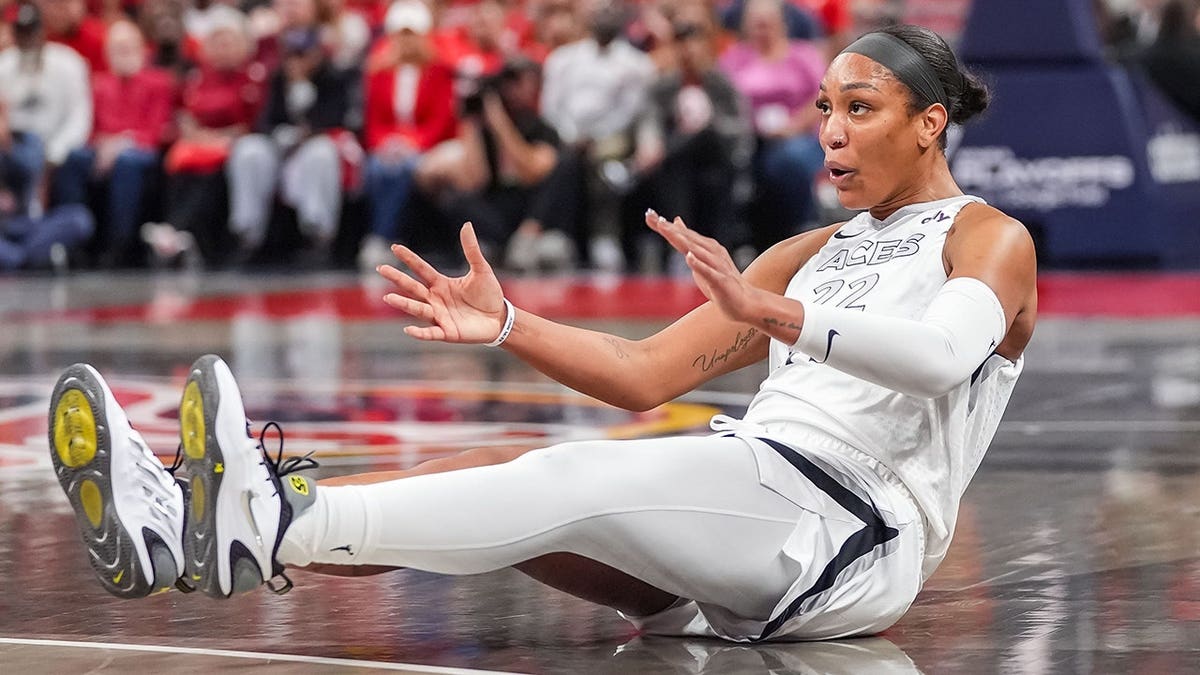 A'ja Wilson, Las Vegas Aces center, slides across the floor during a WNBA playoff game.